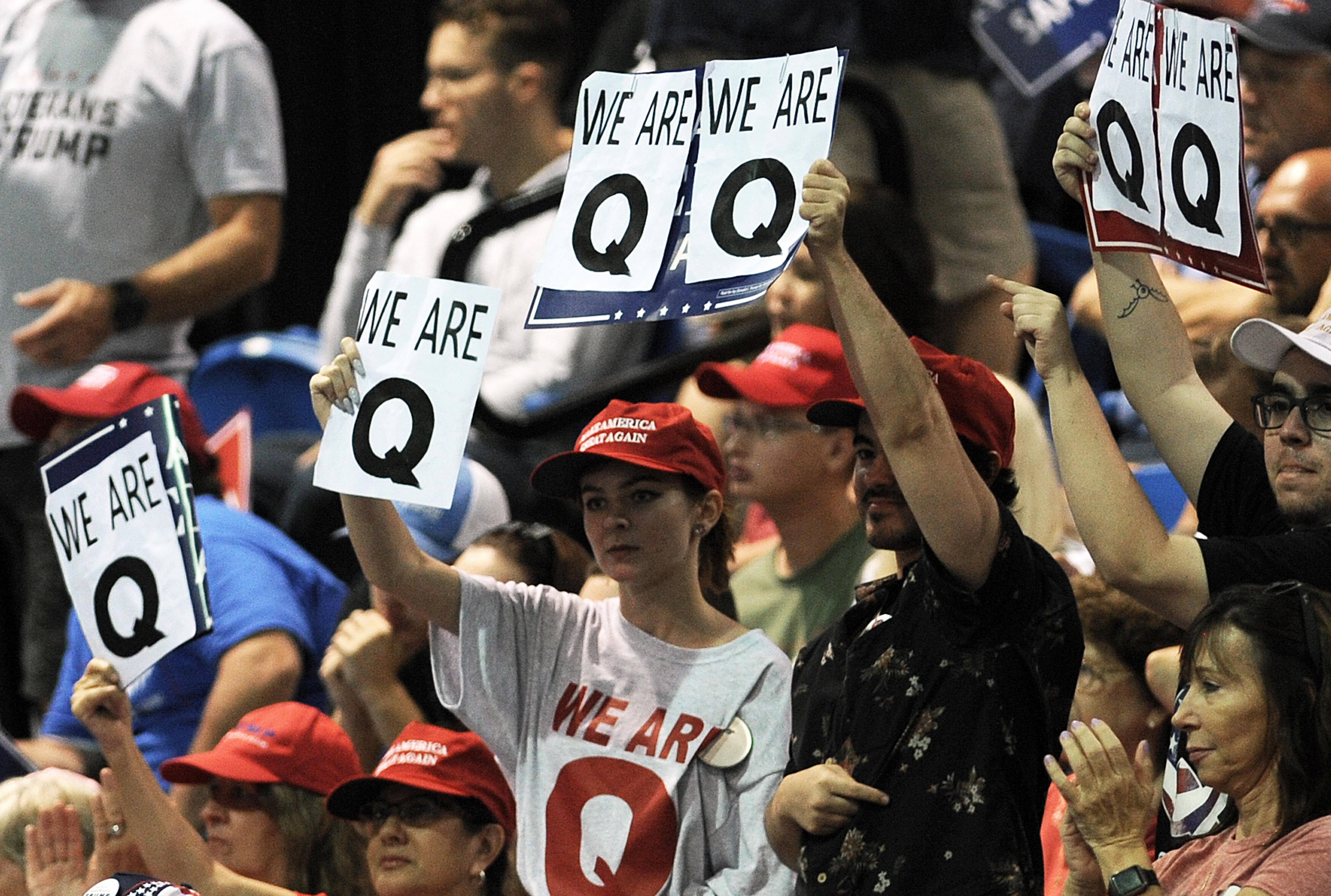 Q Annon supporters holding signs and wearing shirts with large letter Q's on them.